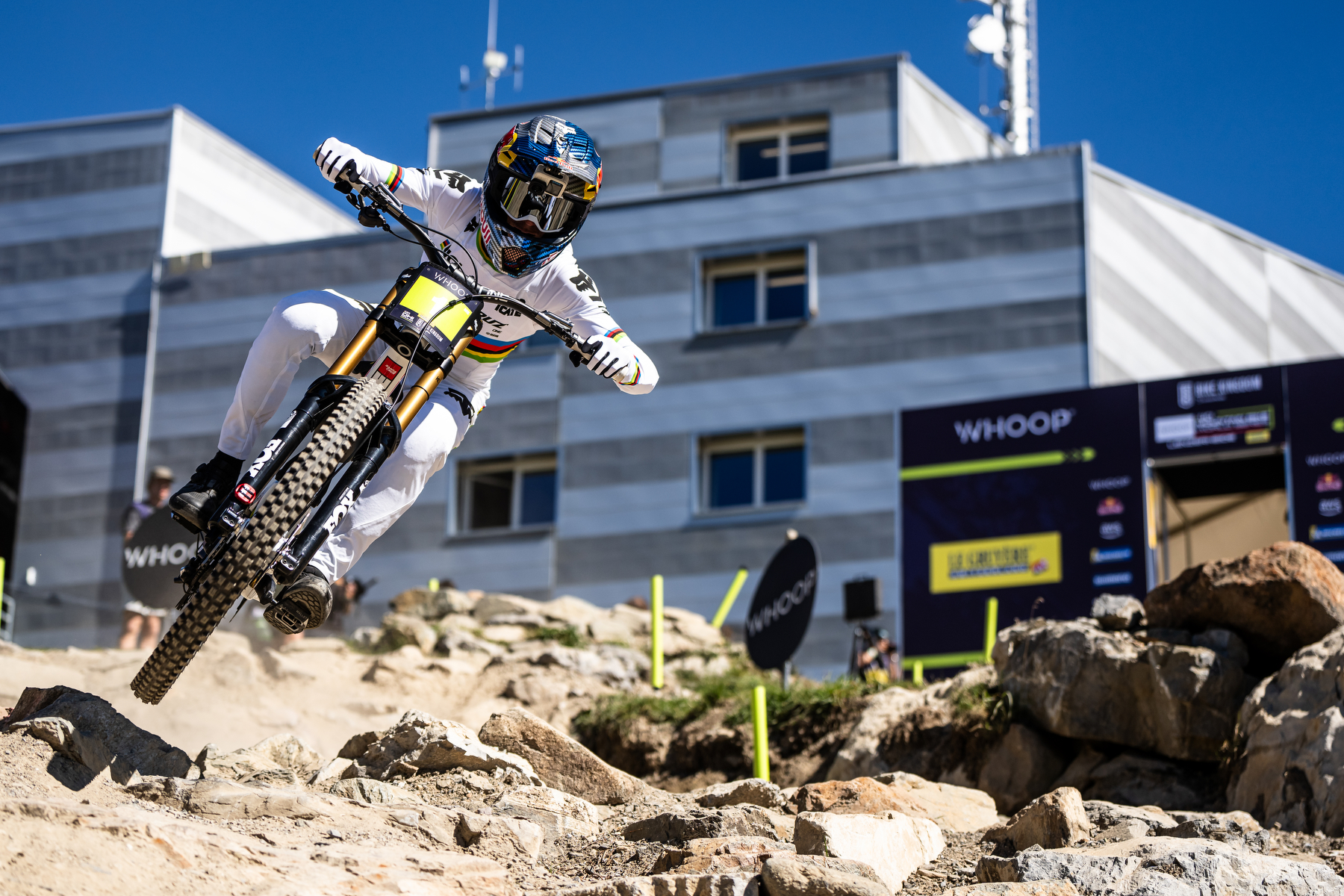 Downhill mountain biker navigates a rocky World Cup course on Maxxis gravity tires during a high-speed descent.