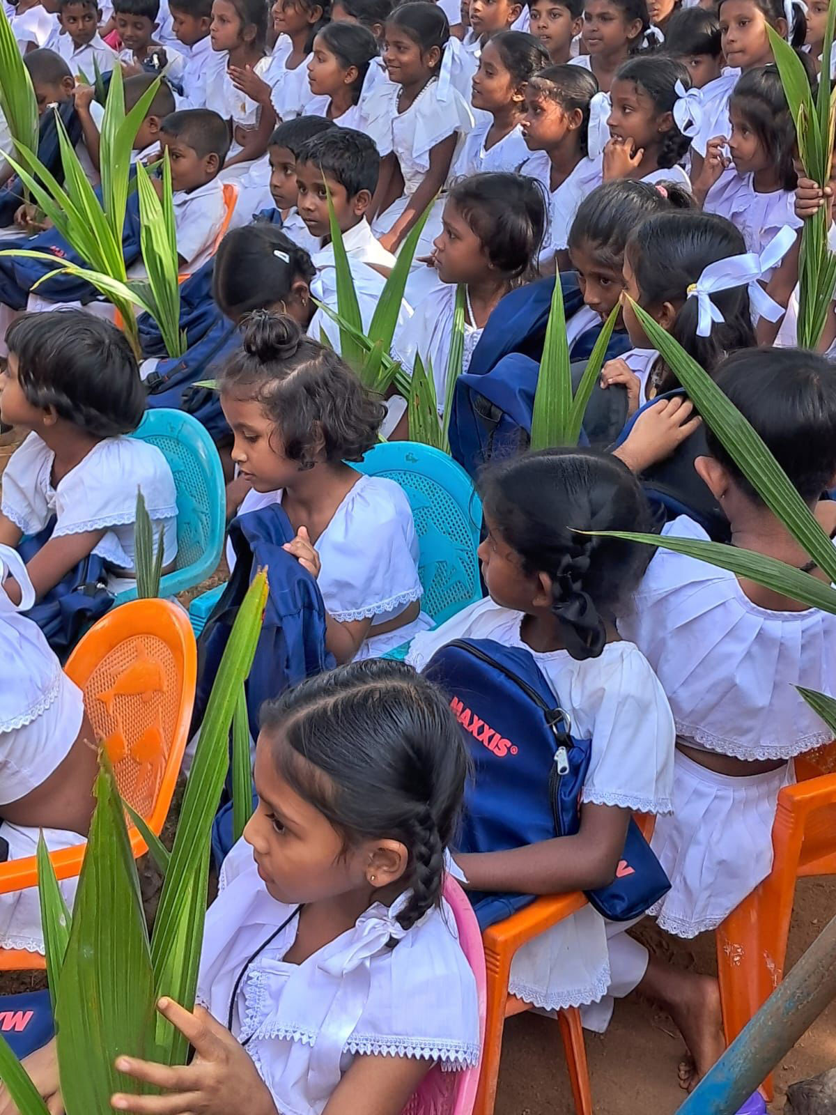 Children holding back packs and coconut trees.
