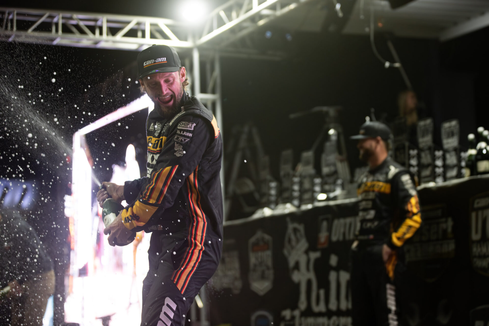 Cody Miller on the KOH podium poping champagne while celebrating his win.