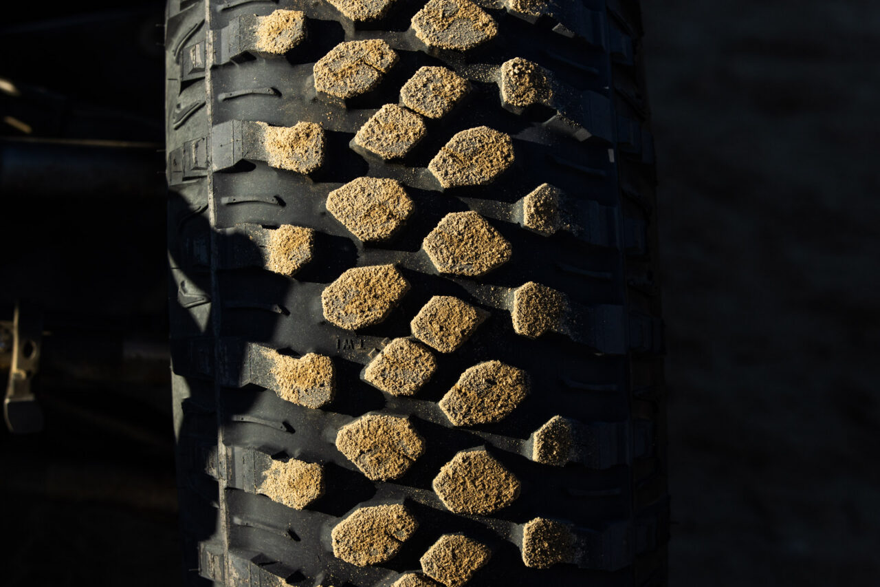 Tight shot of the tread of the Maxxis RAZR XT. A light coating of sand is sticking to each tread block.