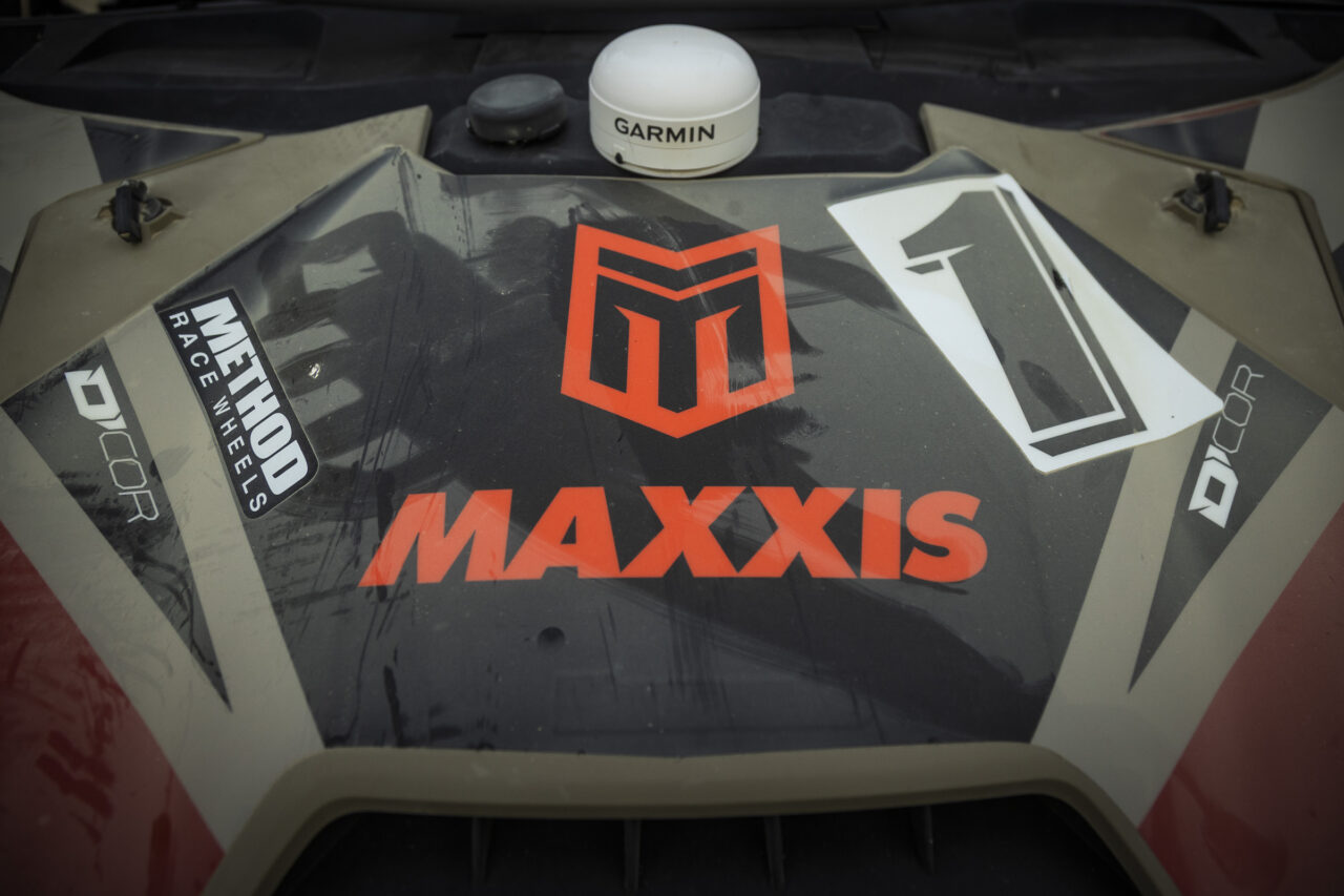black hood with the MAXXIS logo and M ikon front and center with a bold black number 1 over white background.