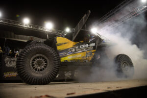 a yellow and black CanAm doing a burnout on the KOH pdoium.