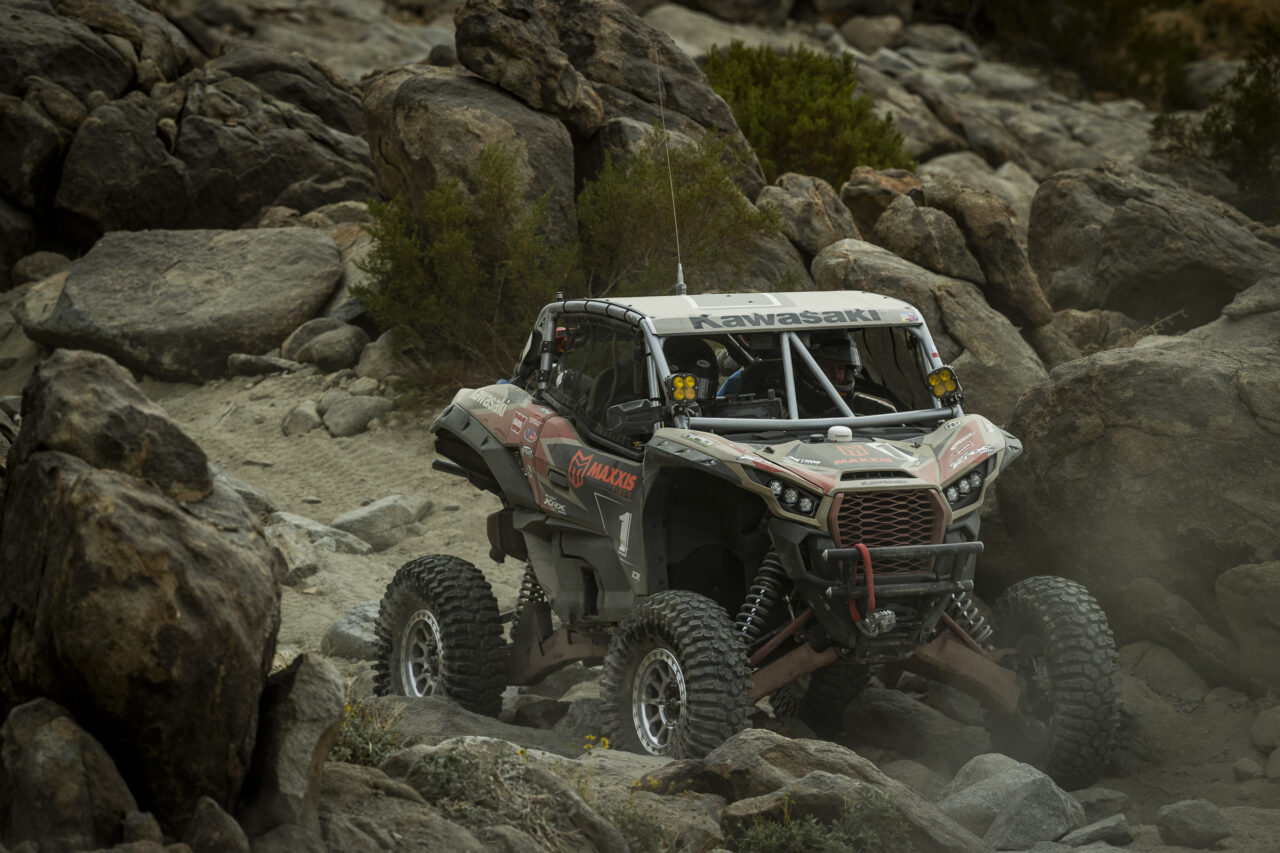 Maxxis athlete Jeremy McGrath navigating a rocky decent at speed in his red and black KRX SxS.