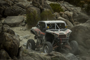Maxxis athlete Jeremy McGrath navigating a rocky decent at speed in his red and black KRX SxS.