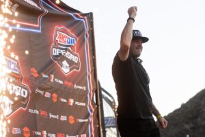 Maxxis Athlete Jimmy Henderson celebrating with his arm raised.