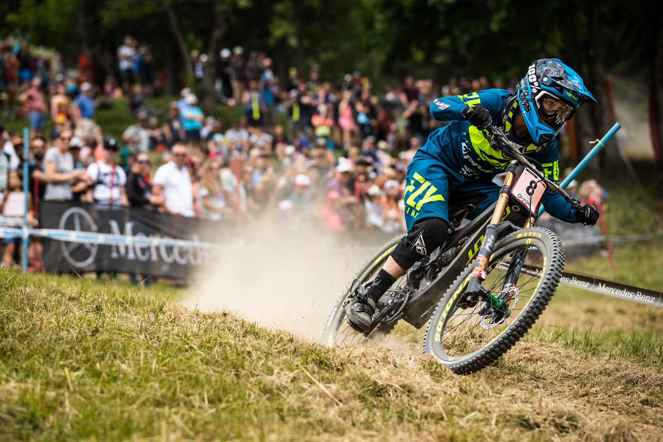 Emilie Siegenthaler leans the bike around a grass corner.