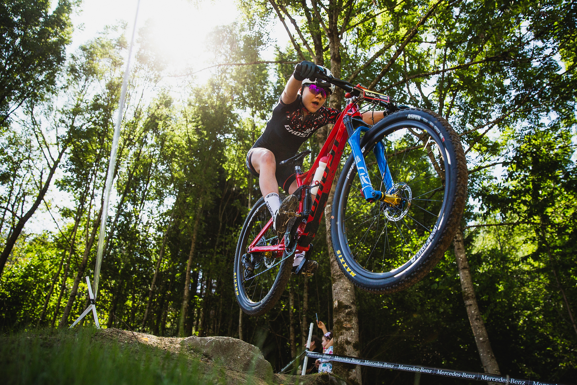 Sina Frei puts both wheels in the air off of a rock drop.