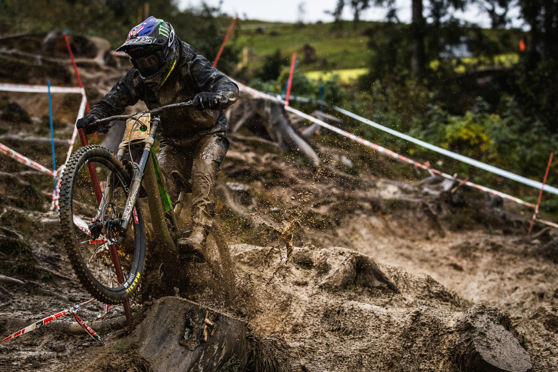 DH rider making a muddy splash at the World Cup