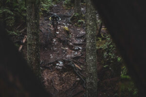 Kona athlete riding down a rooty section