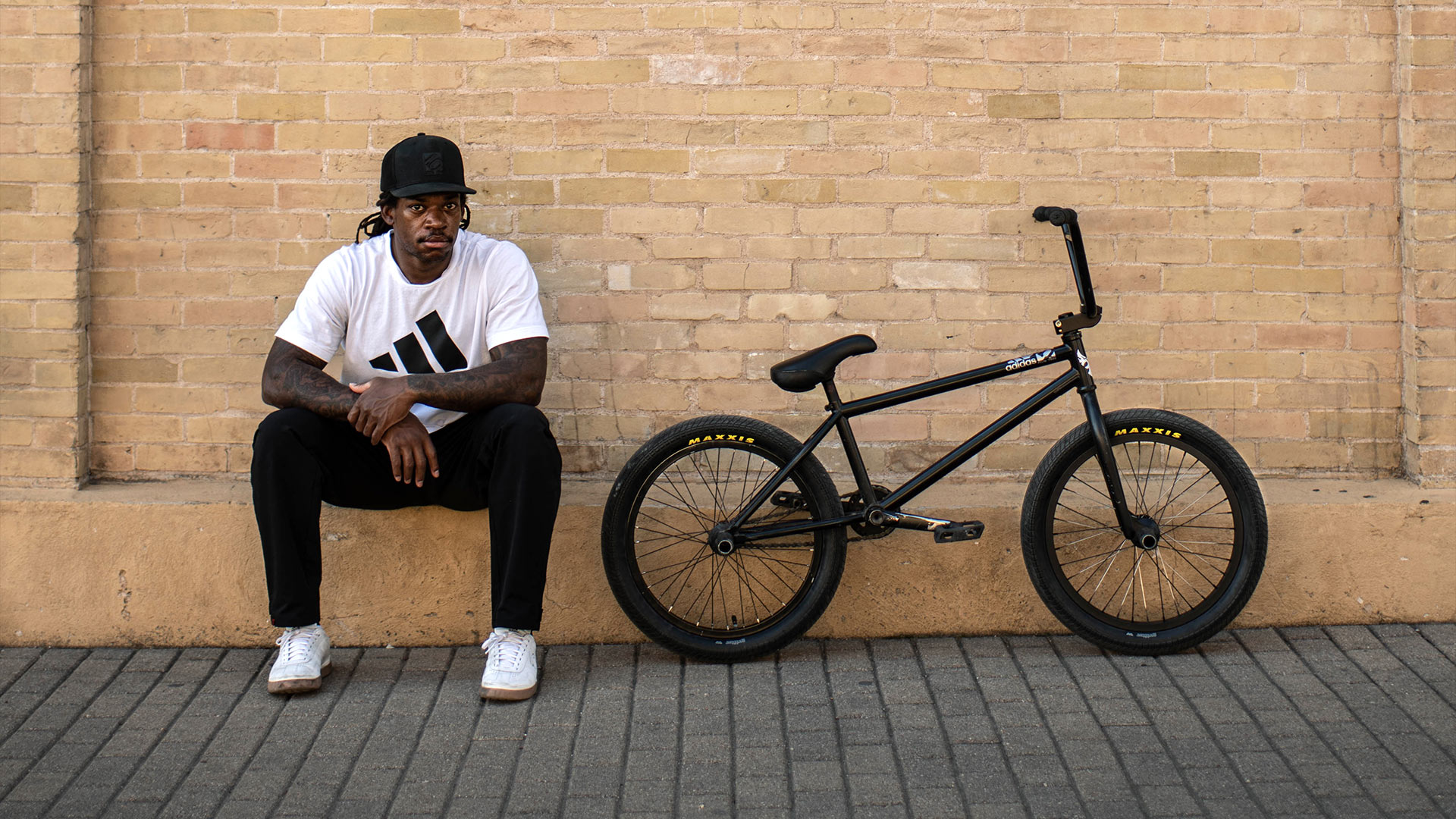 Brad Simms sitting next to his bmx bike.