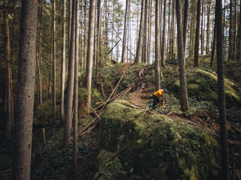 Rocky Mountain athlete riding down mossy rock face