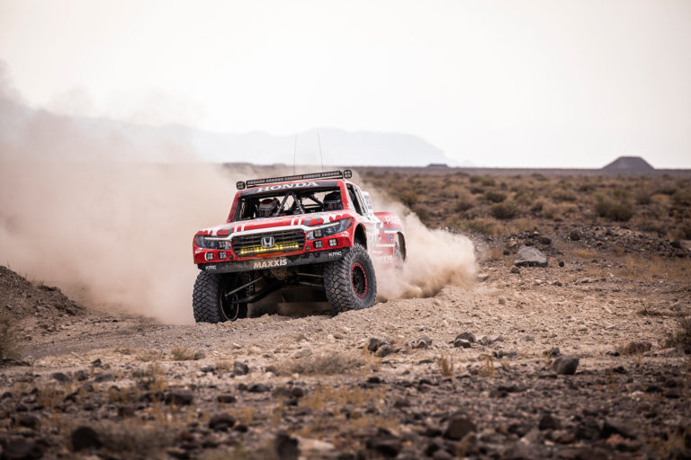 A Honda Offroad Racing Ridgeline racing through the desert.