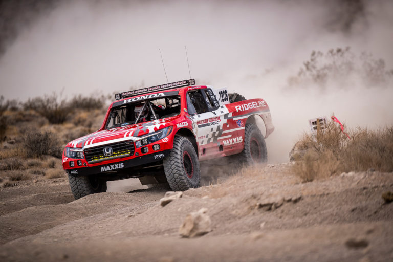 A Honda Offroad Racing Ridgeline racing through the desert.