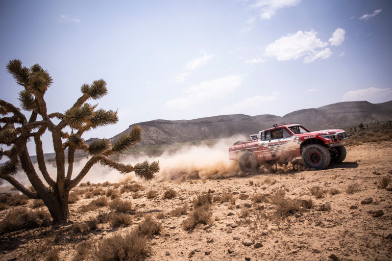 A Honda Offroad Racing Ridgeline racing through the desert.