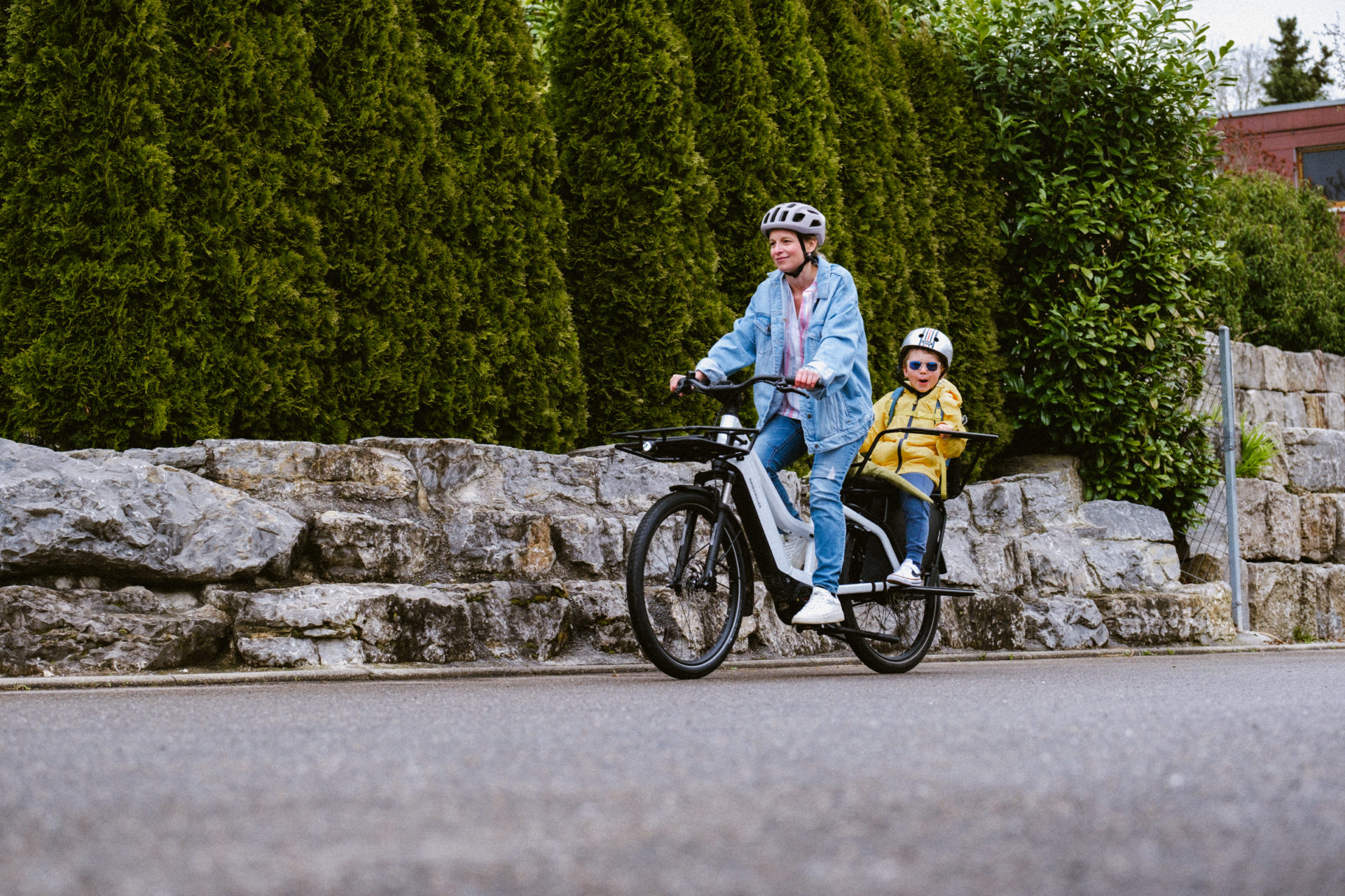 A mother and son ride an electric bicycle.