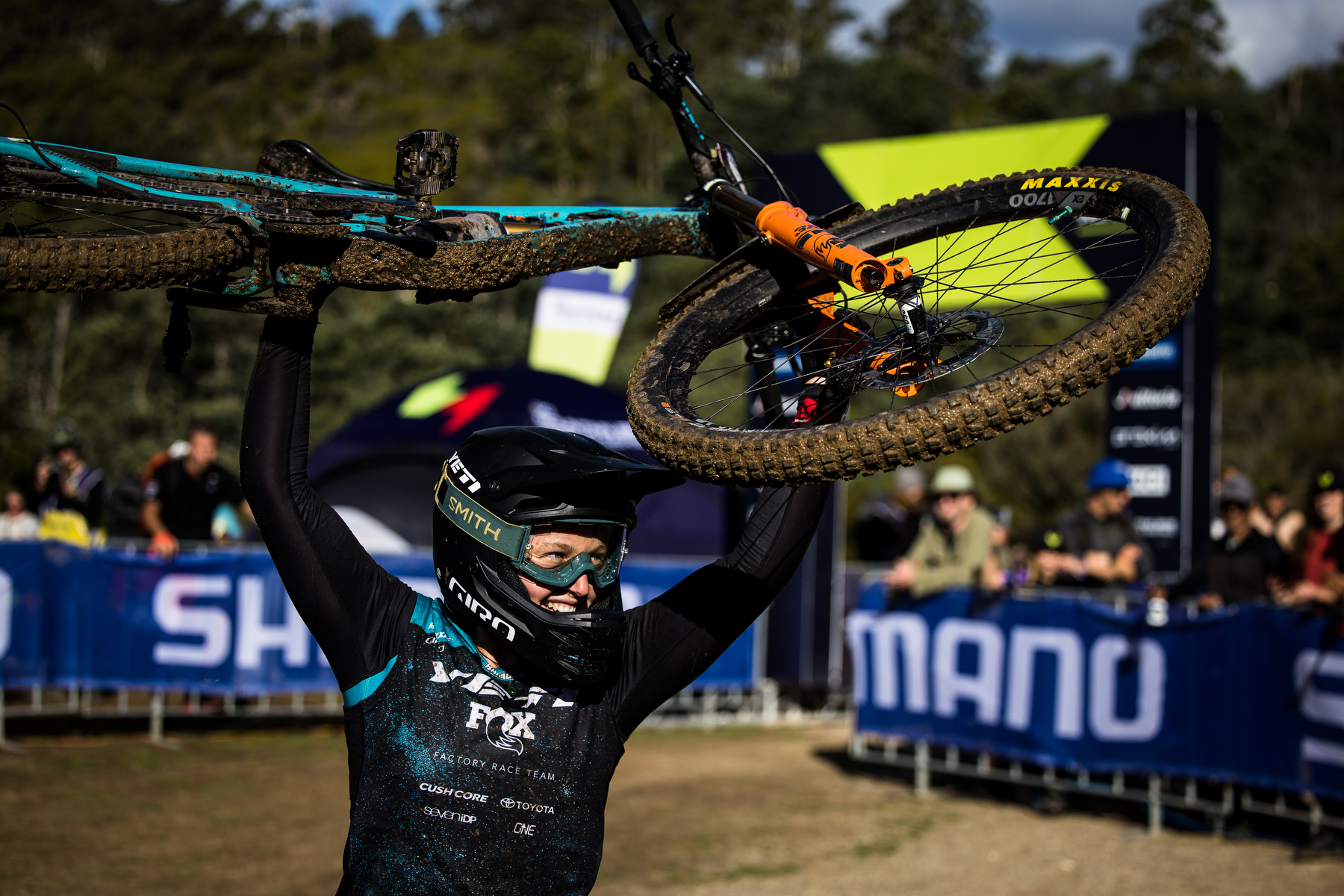 Yeti rider lifting their bike above their head in victory