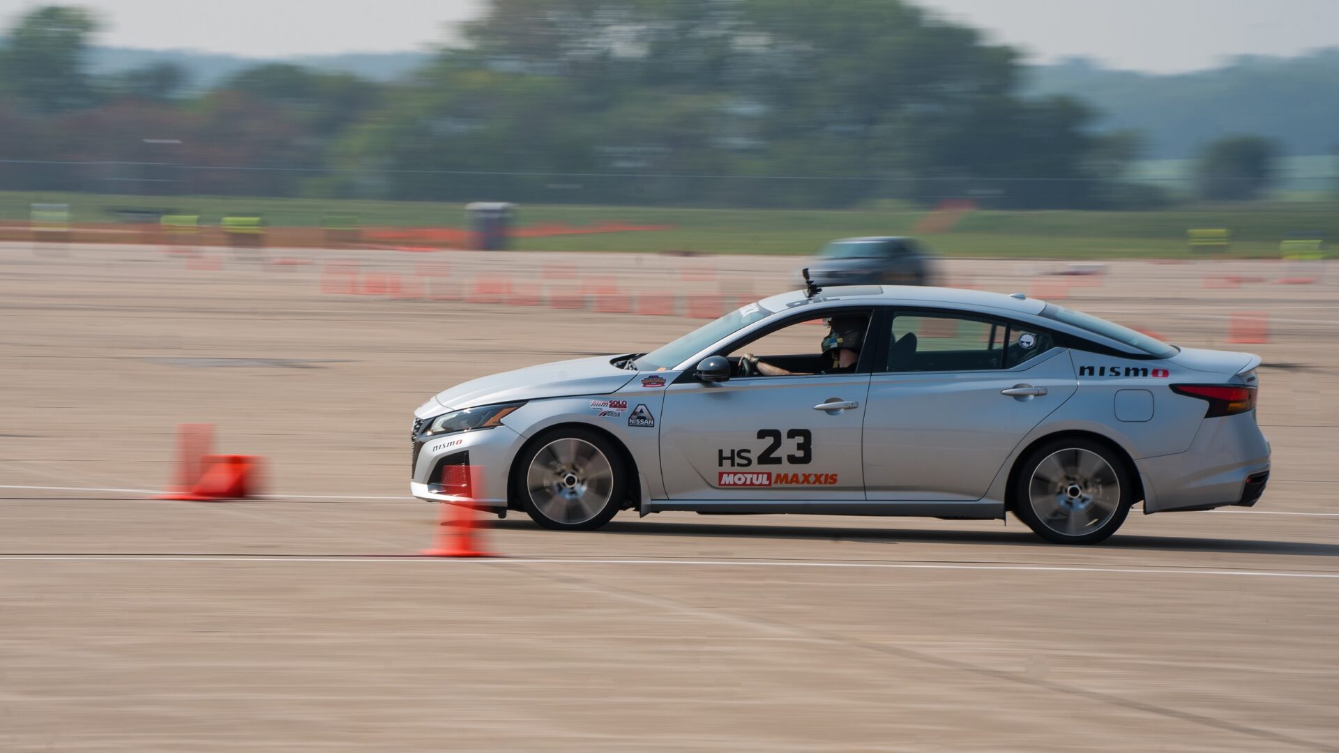 Nissan Acceleration Team's silver Nissan sedan racing