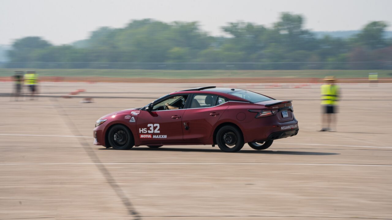 Nissan Acceleration Team's red Nissan sedan racing