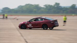 Nissan Acceleration Team's red Nissan sedan racing