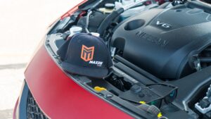 Nissan Acceleration Team's Maxxis hat on car's engine compartment.