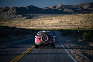 Scenic open road view of HART Team #208 vehicle Honda Pilot Trail Sport driving away on asphalt road