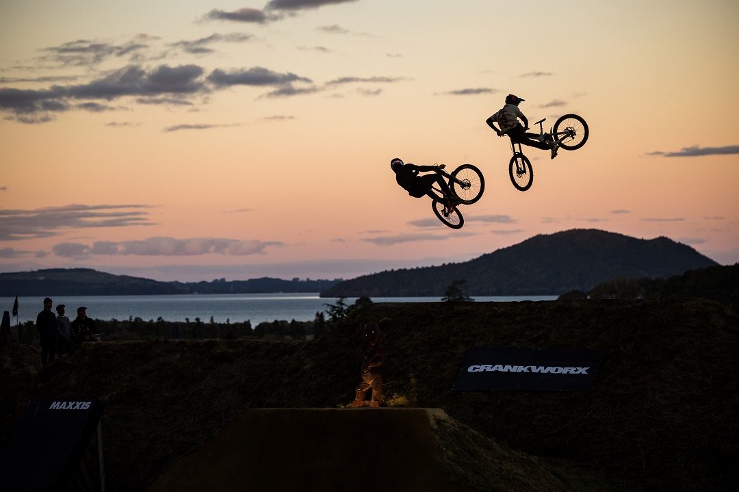 Two riders jumping into the sunset