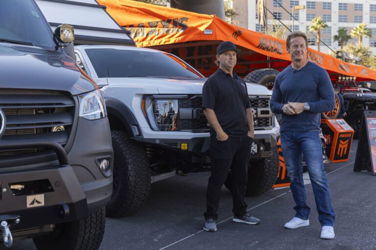 Jeremy and another man standing in front of the Maxxis support truck outside at the 2023 SEMA show