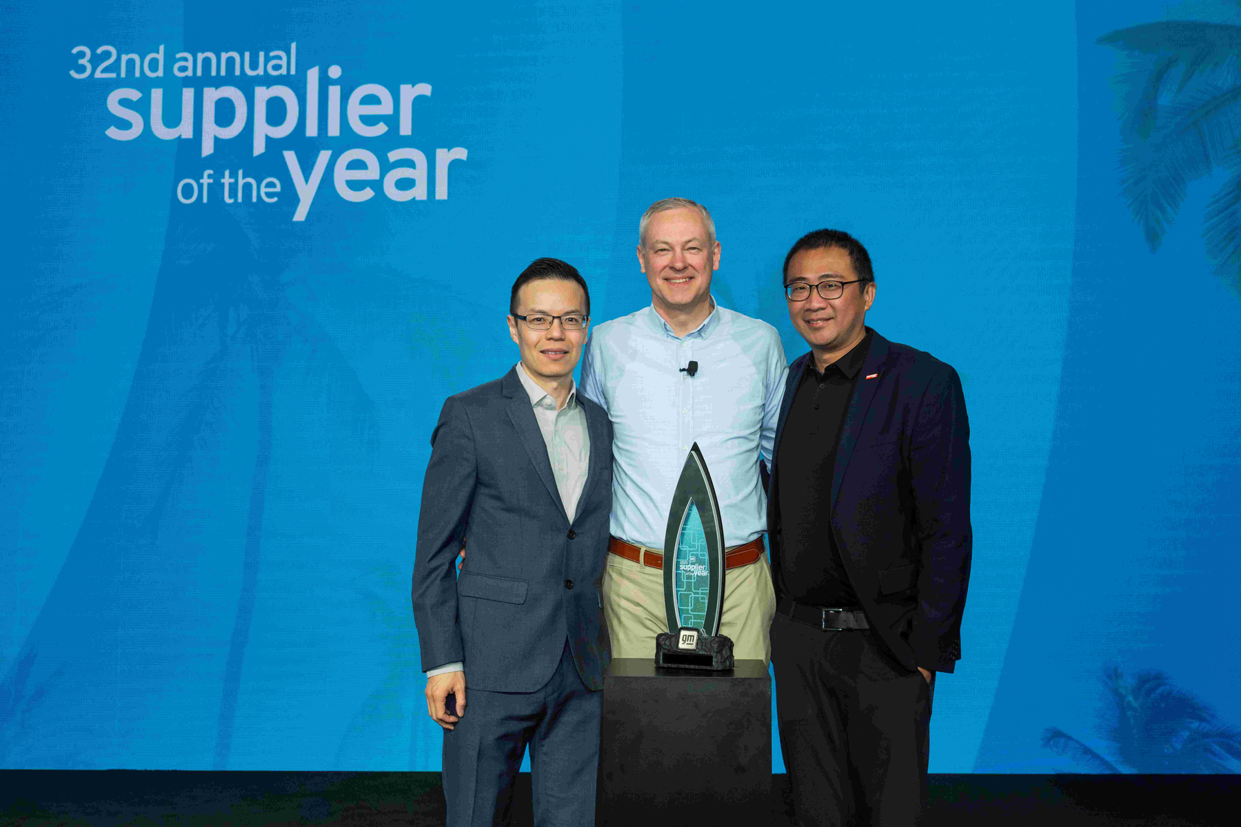 GM 32nd Annual Supplier of the Year award event, three men standing with the Supplier of the Year award