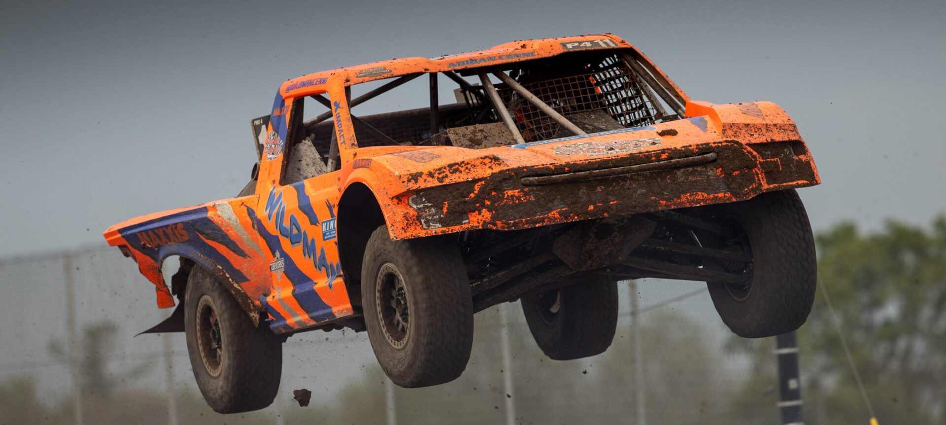 Orange and blue truck jumping through the air.
