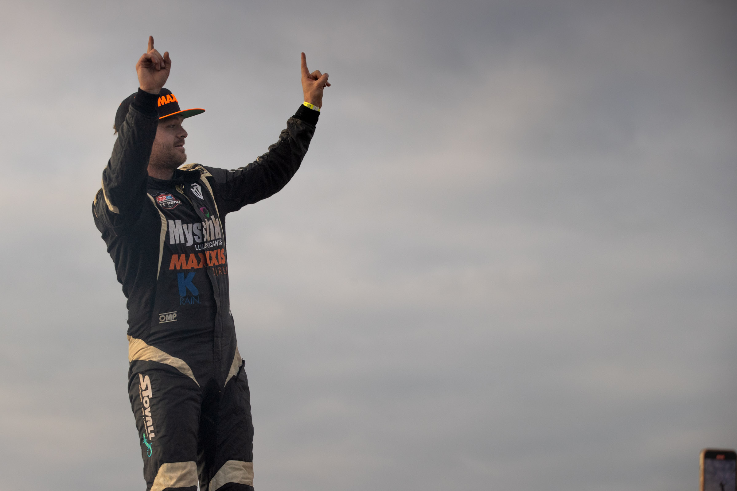 Maxxis athlete celebrating, holding up hands after the race