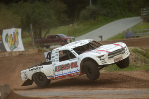 Maxxis sponsored driver lifting the truck in the air through some spirited driving.