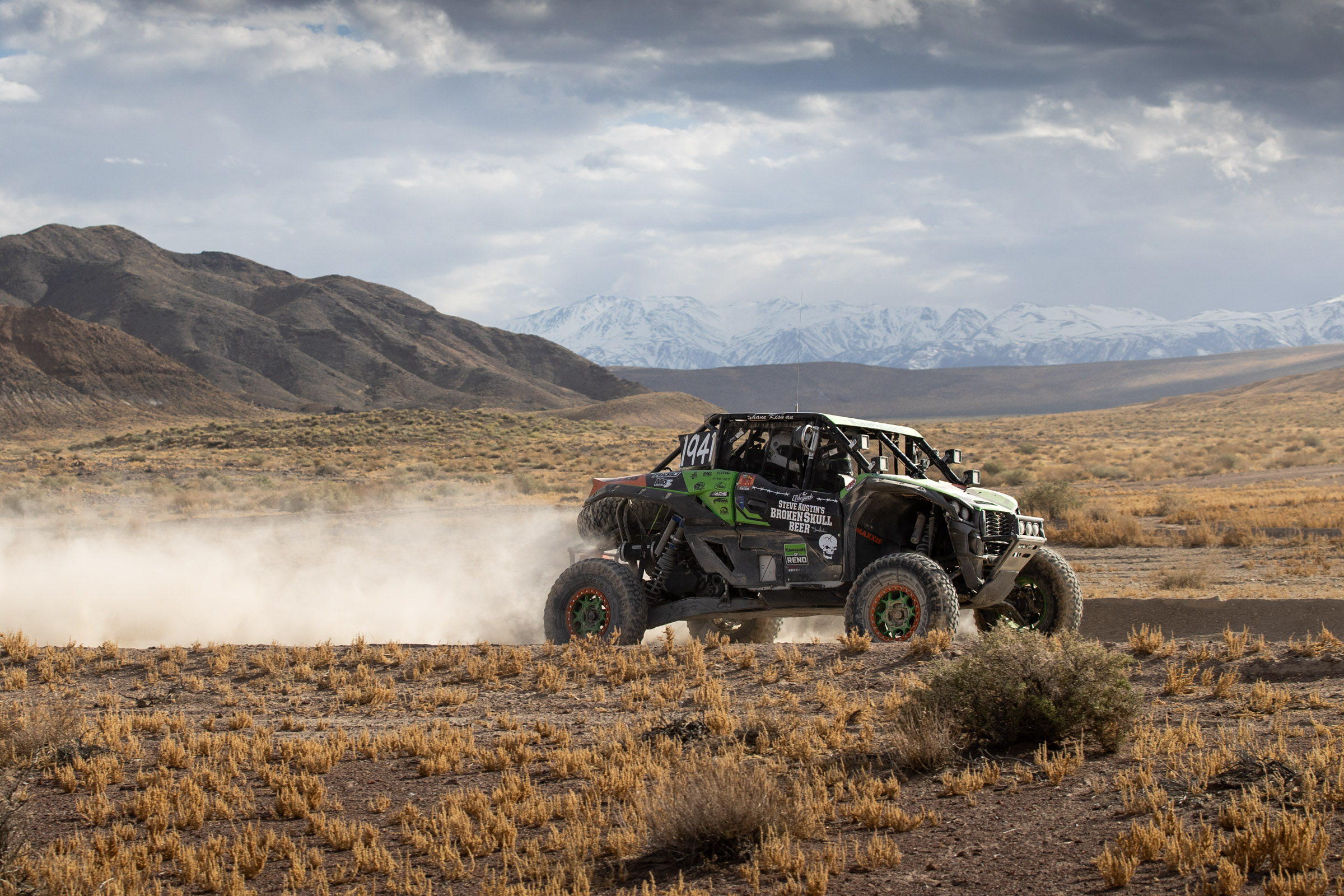 GFI Racing's Zach Kissman racing across a dry lake bead in a picturesque desert setting.