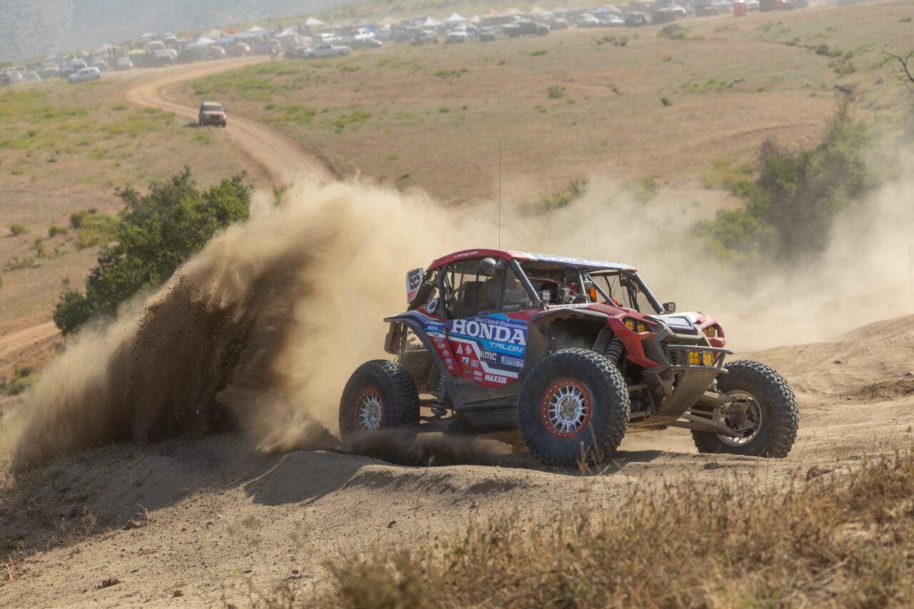 A Honda Talon SxS racing up a desert hill.