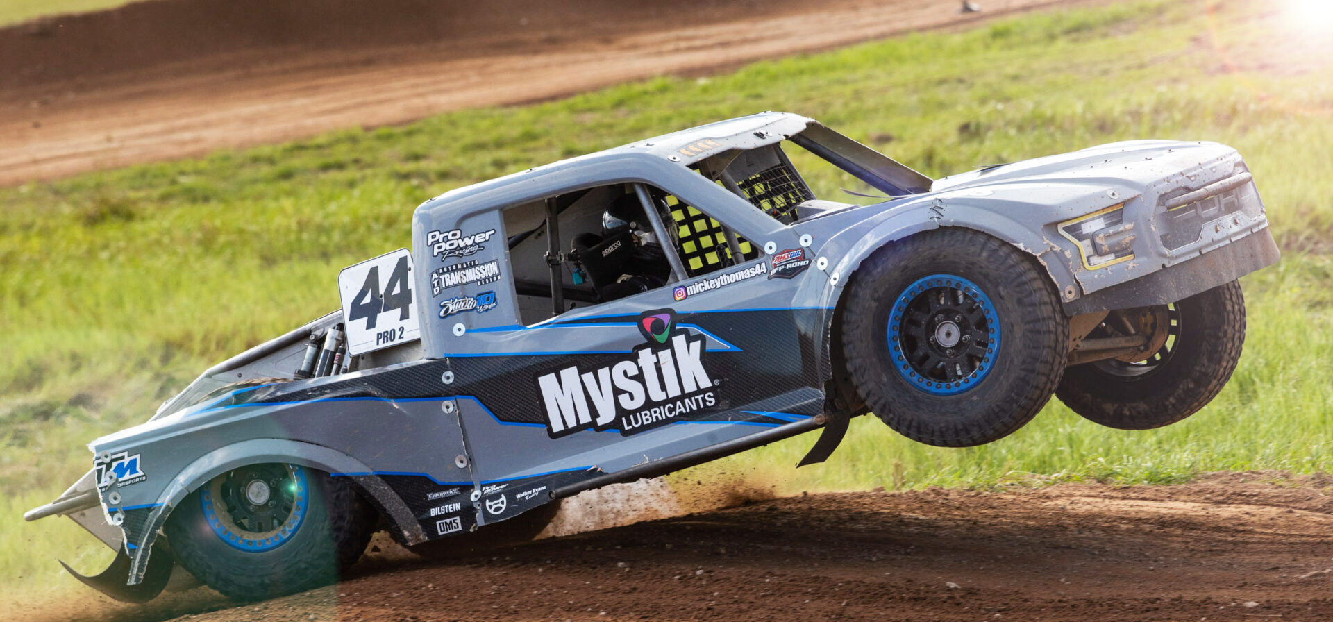 Maxxis sponsored truck lifting the front end in the air off a jump.