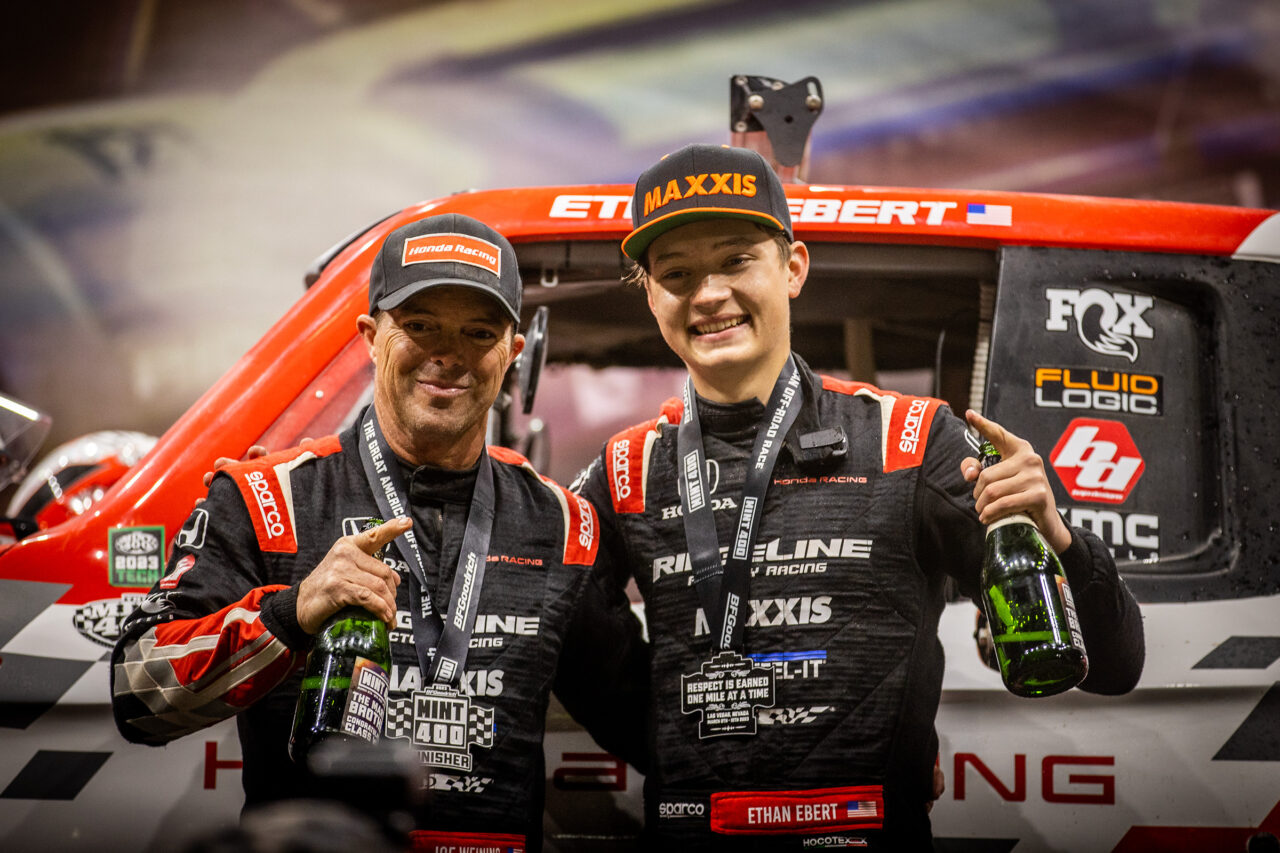 Ethan Ebert and his old Co Driver on the podium after a win in the Mint 400 in 2023.