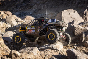 Kyle chaney in his black and yellow CanAm SxS navigating a rock section in the 4400 Class race of KOH 2025.