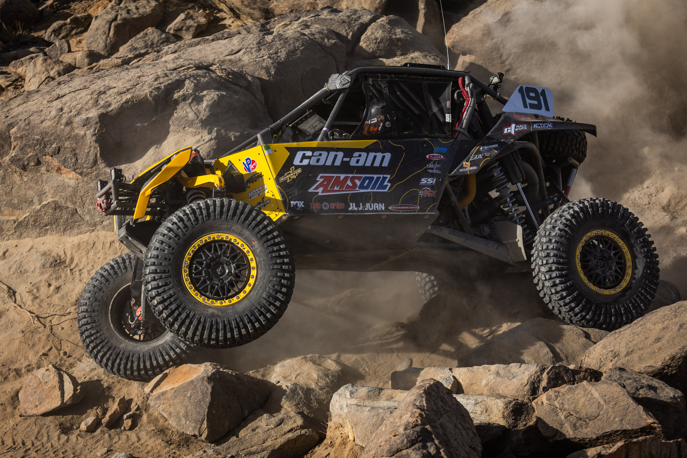 Kyle chaney in his black and yellow CanAm SxS navigating a rock section in the 4400 Class race of KOH 2025.