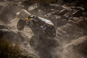 Kyle chaney in his black and yellow CanAm SxS navigating a rock section in the 4400 Class race of KOH 2025.