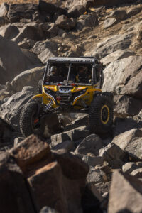 Kyle chaney in his black and yellow CanAm SxS navigating a rock section in the 4400 Class race of KOH 2025.
