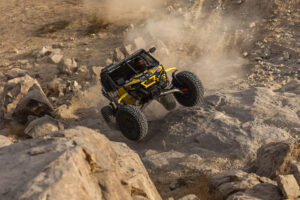 Kyle Chaney overtaking one of the rock obstacles in his yellow CanAm.