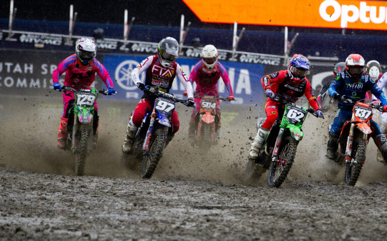 PRMX Maxxis Racer covered in mud while racing his green dirtbike in 250 SX.