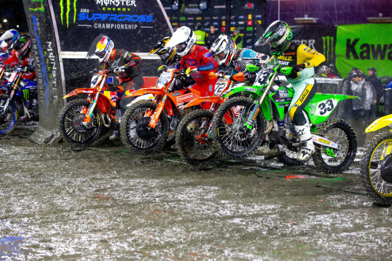 a row of 450cc dirt bikes launching from the metal starting gate at the 2025 Foxborough round of Supercross.