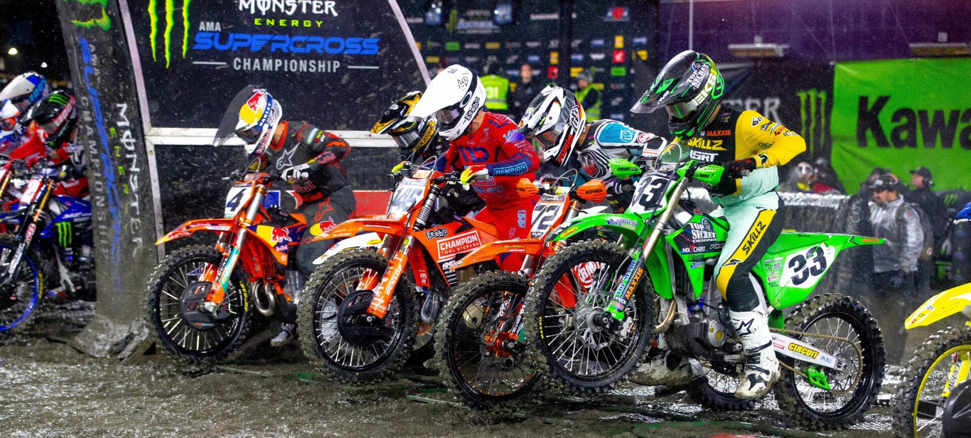 a row of 450cc dirt bikes launching from the metal starting gate at the 2025 Foxborough round of Supercross.