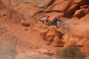 Maxxis athlete throwing dust up on the trail. Top view.