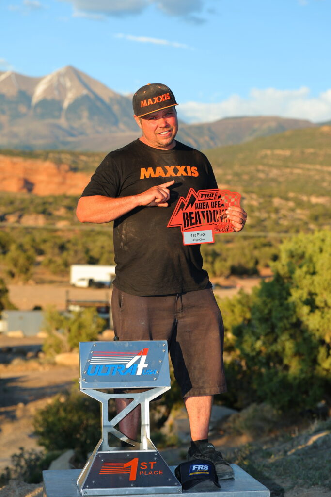 Maxxis athlete, holding a trophy following a win.