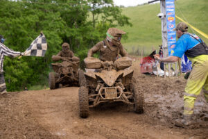 GNCC Maxxis athlete Hunter Hart coasting across the finish line of the Mason Dixon GNCC covered in Mud.