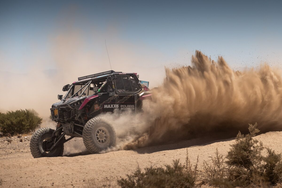 Maxxis athlete throwing up a roost of dust