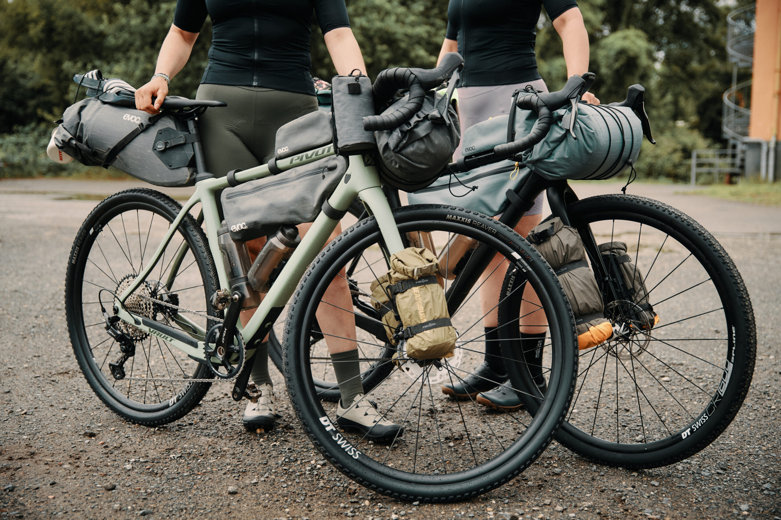 A closeup of two bicycles and riders