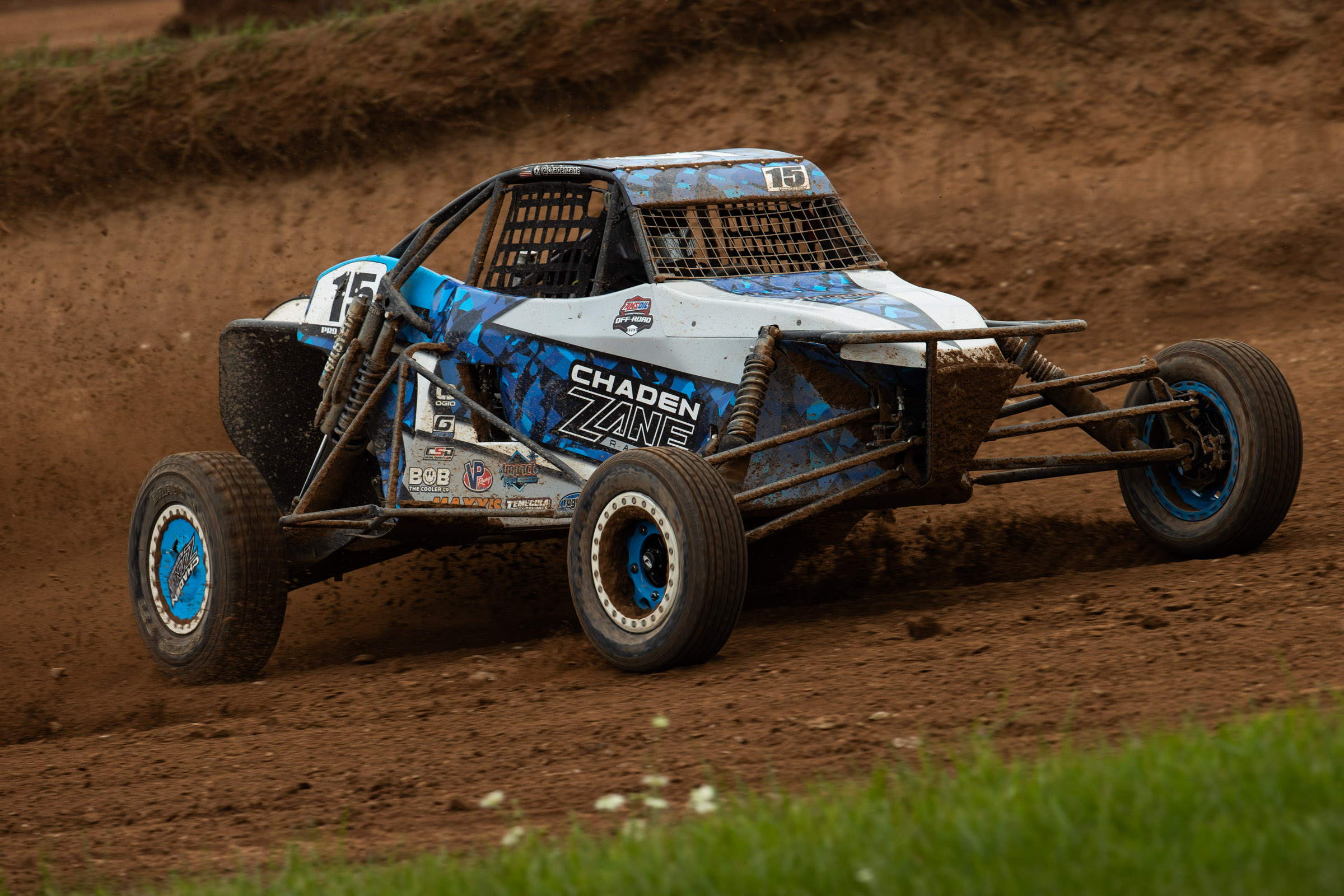 Blue and Grey race cart pinned in a left hand turn.