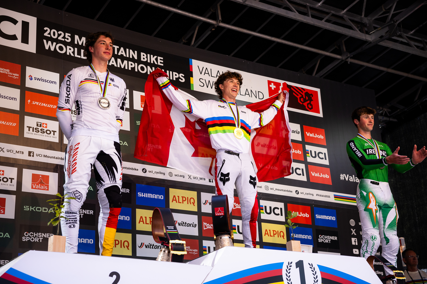 Goldstone on podium holding Canadian flag